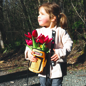 Little girl holding a Wild Wolf Outfitters water bottle sleeve with flowers in it